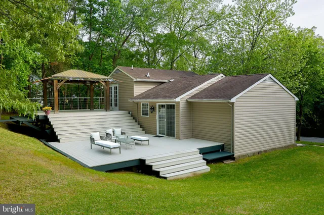 a view of a house with backyard and sitting area