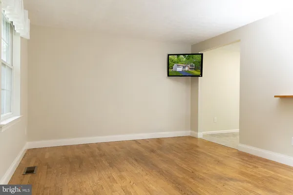 a view of a wall with wooden floor and window
