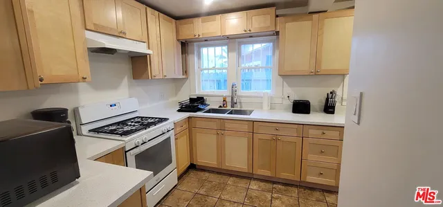 a kitchen with a refrigerator and white cabinets