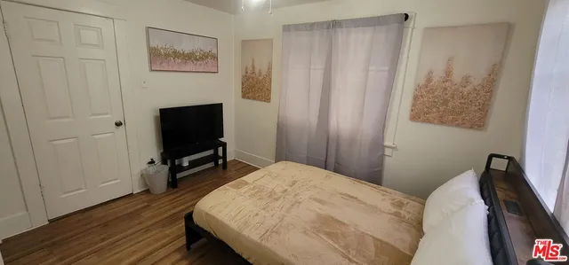 a bedroom with a bed and a flat tv screen