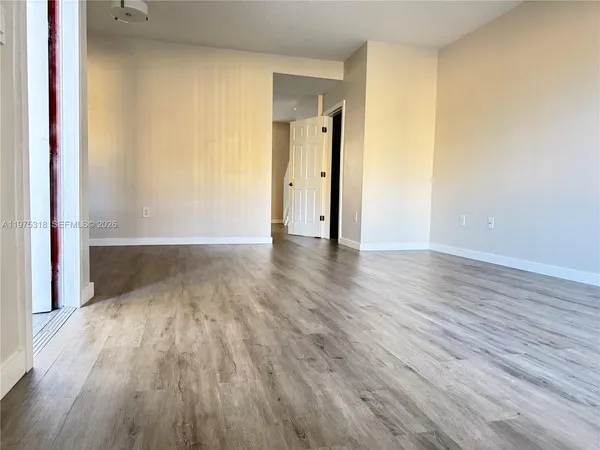a view of an empty room and wooden floor