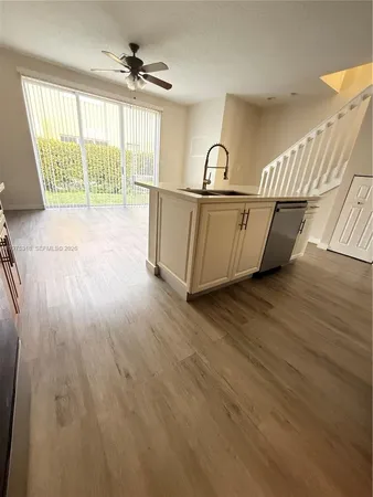 a view of a kitchen with a sink and a refrigerator