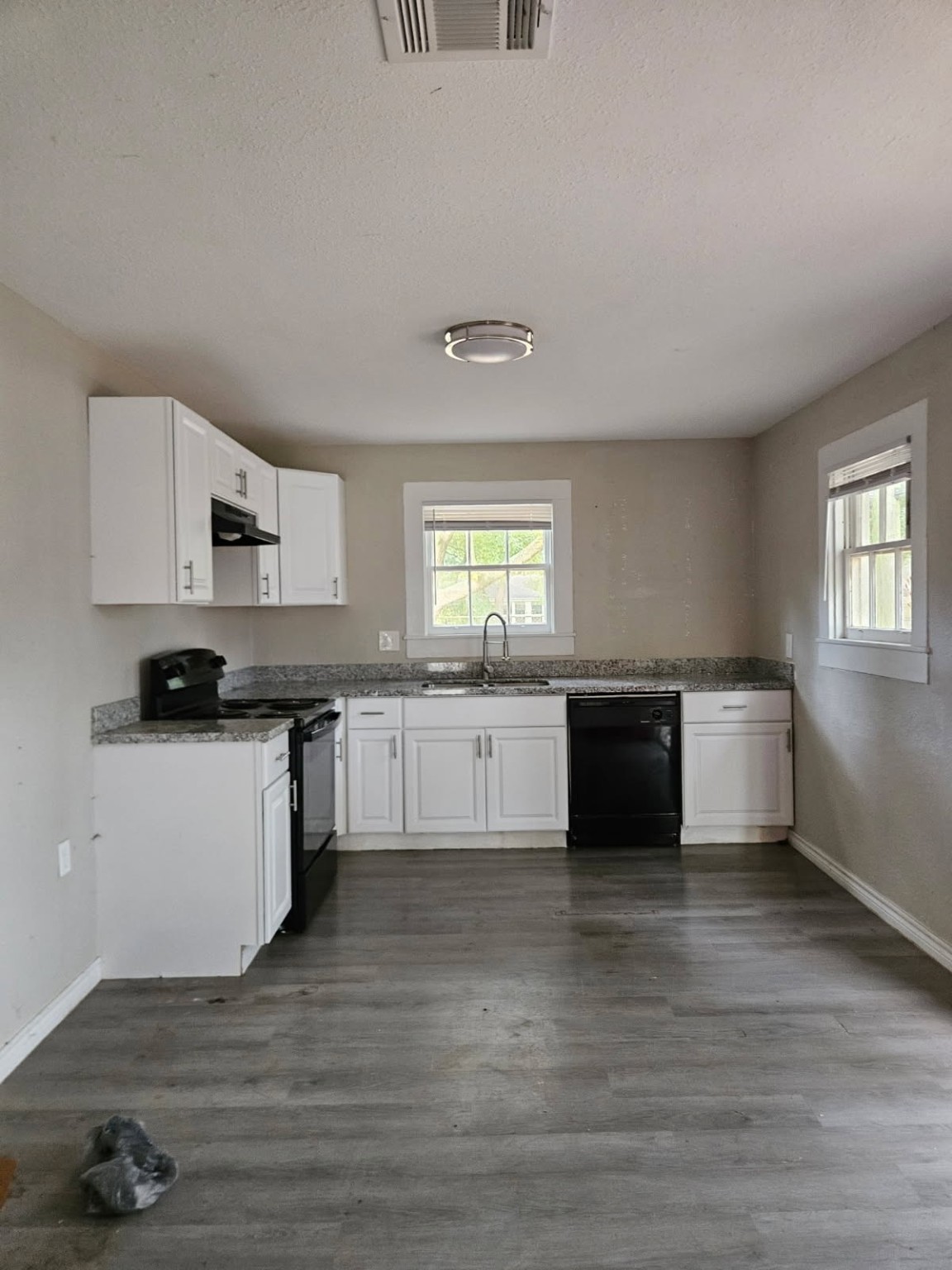 311 South Amburn Road Texas City, TX 77591 - Photo 4 of 7 a kitchen with granite countertop a sink cabinets and wooden floor
