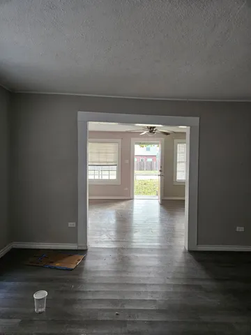 a view of empty room with window and wooden floor