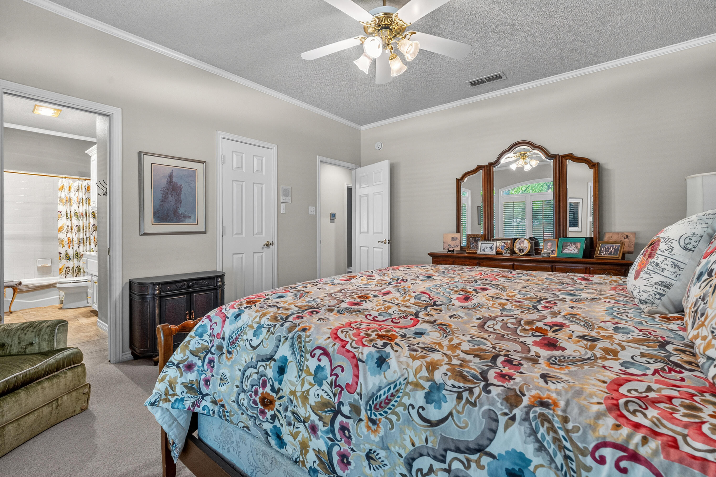 7402 95th Street Lubbock, TX 79424 - Photo 25 of 43 a bedroom with a bed and a chandelier