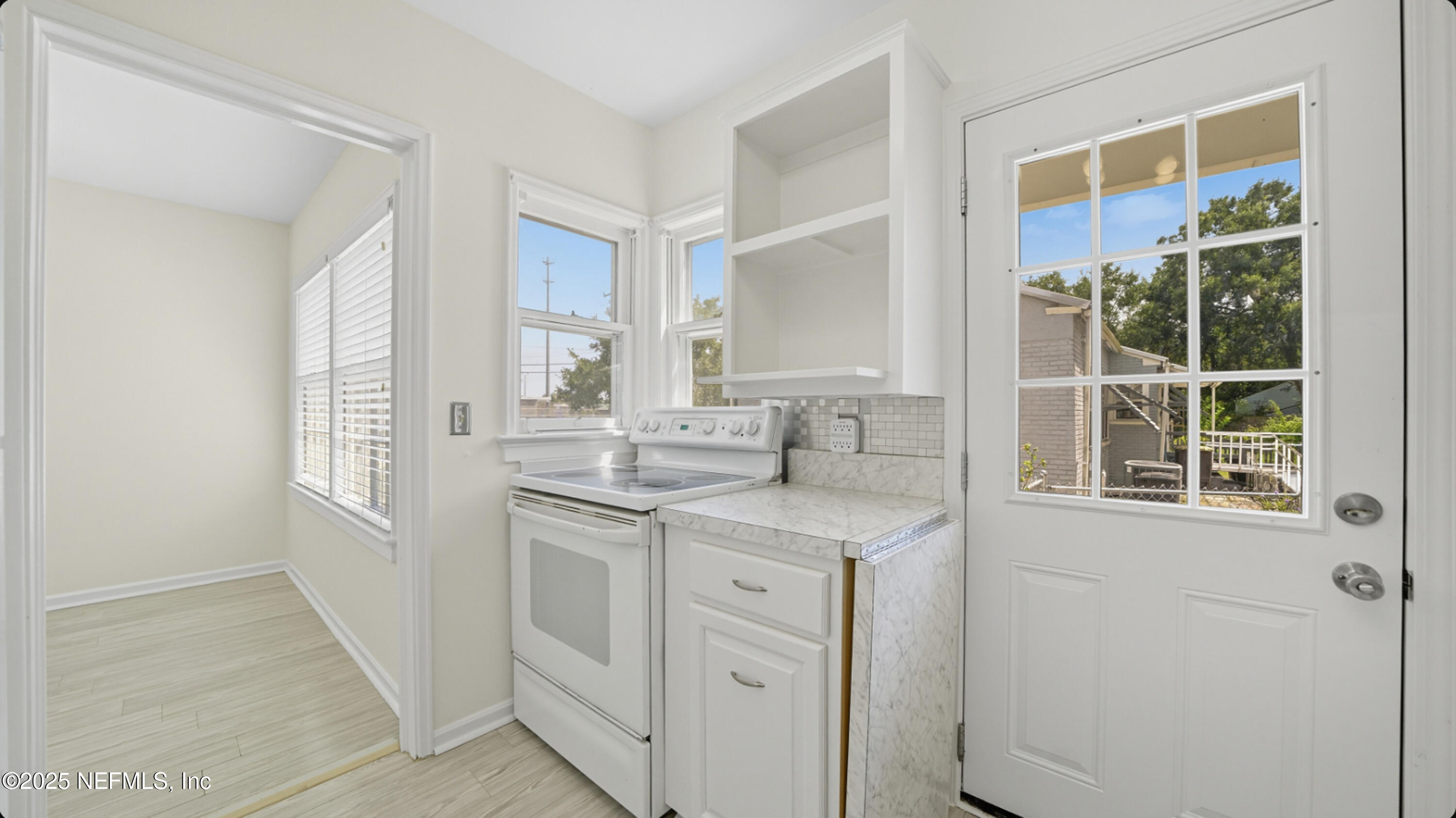 2604 Bayview Road Jacksonville, FL 32210 - Photo 11 of 31 a kitchen with white cabinets and a window