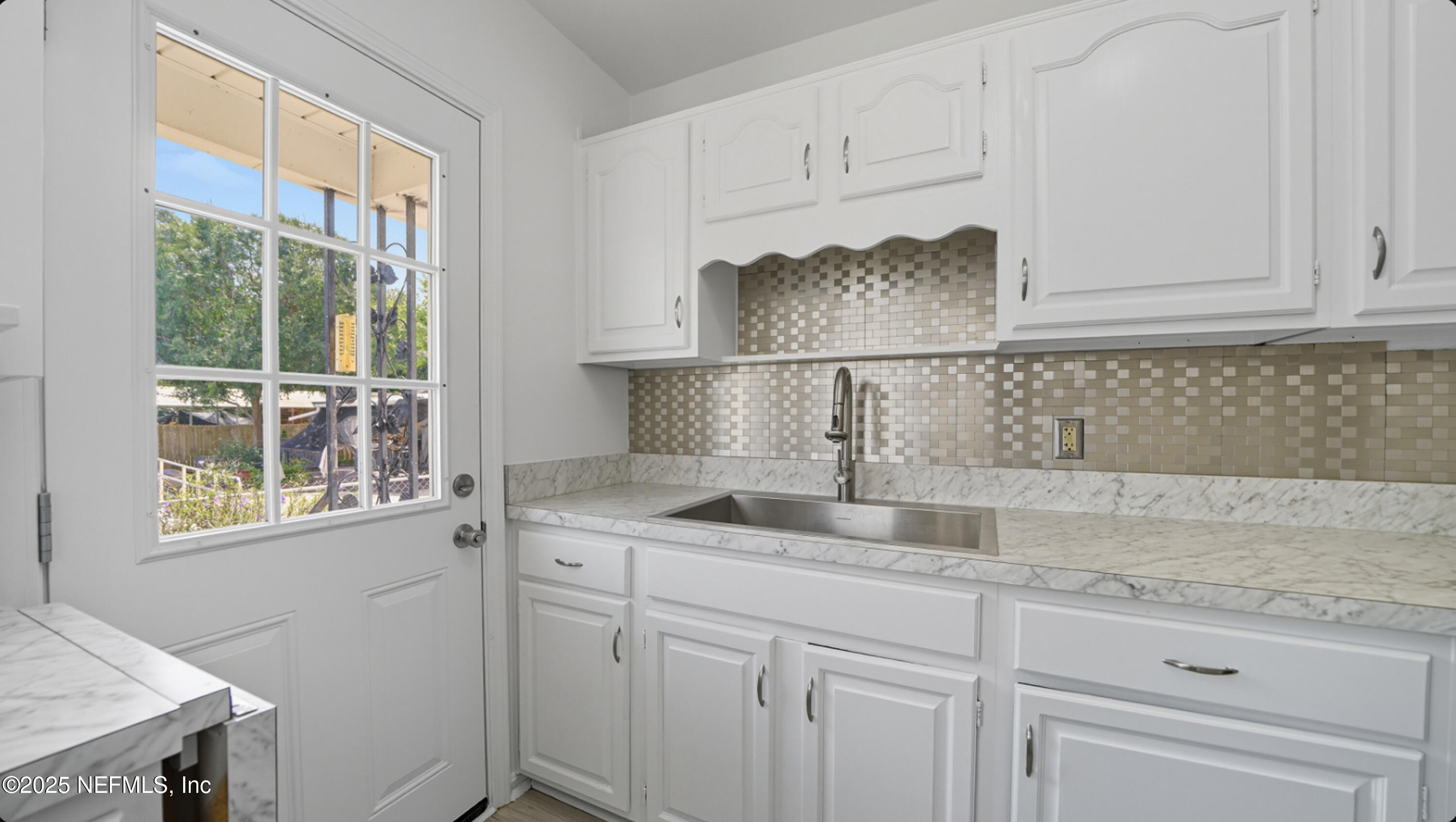 2604 Bayview Road Jacksonville, FL 32210 - Photo 12 of 31 a kitchen with a sink cabinets and window