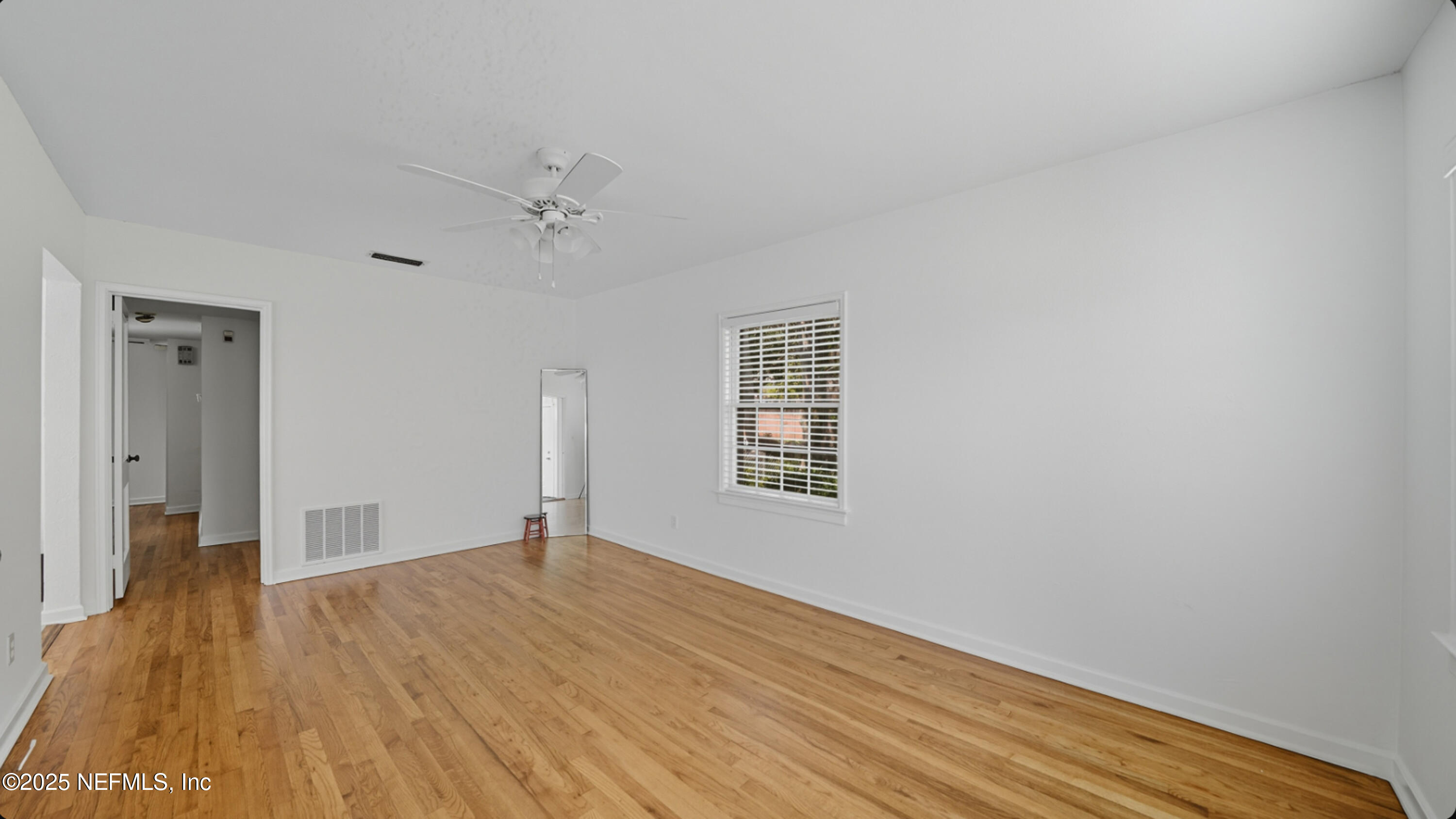 2604 Bayview Road Jacksonville, FL 32210 - Photo 5 of 31 a view of an empty room with wooden floor and a window