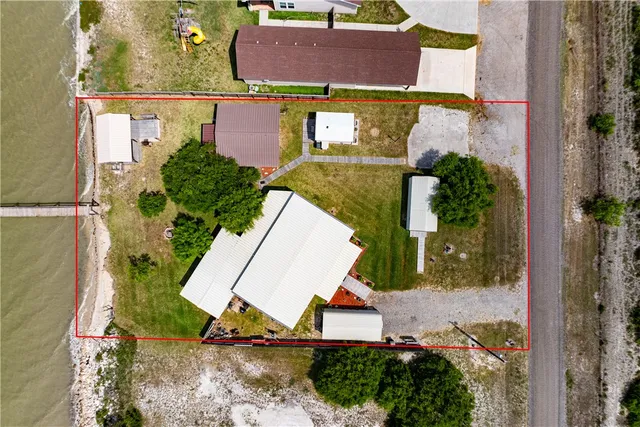 an aerial view of a house with a yard and lake view