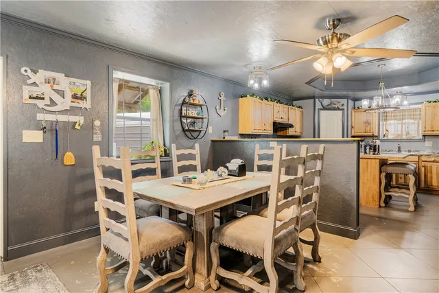 a kitchen with stainless steel appliances granite countertop a refrigerator a sink dishwasher a oven with a dining table and chairs