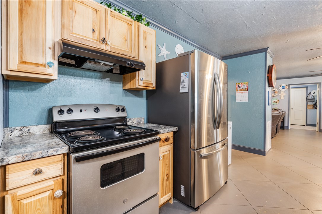 1356 Neubauer Point Road Riviera, TX 78379 - Photo 26 of 40 a kitchen with stainless steel appliances granite countertop a stove microwave and refrigerator
