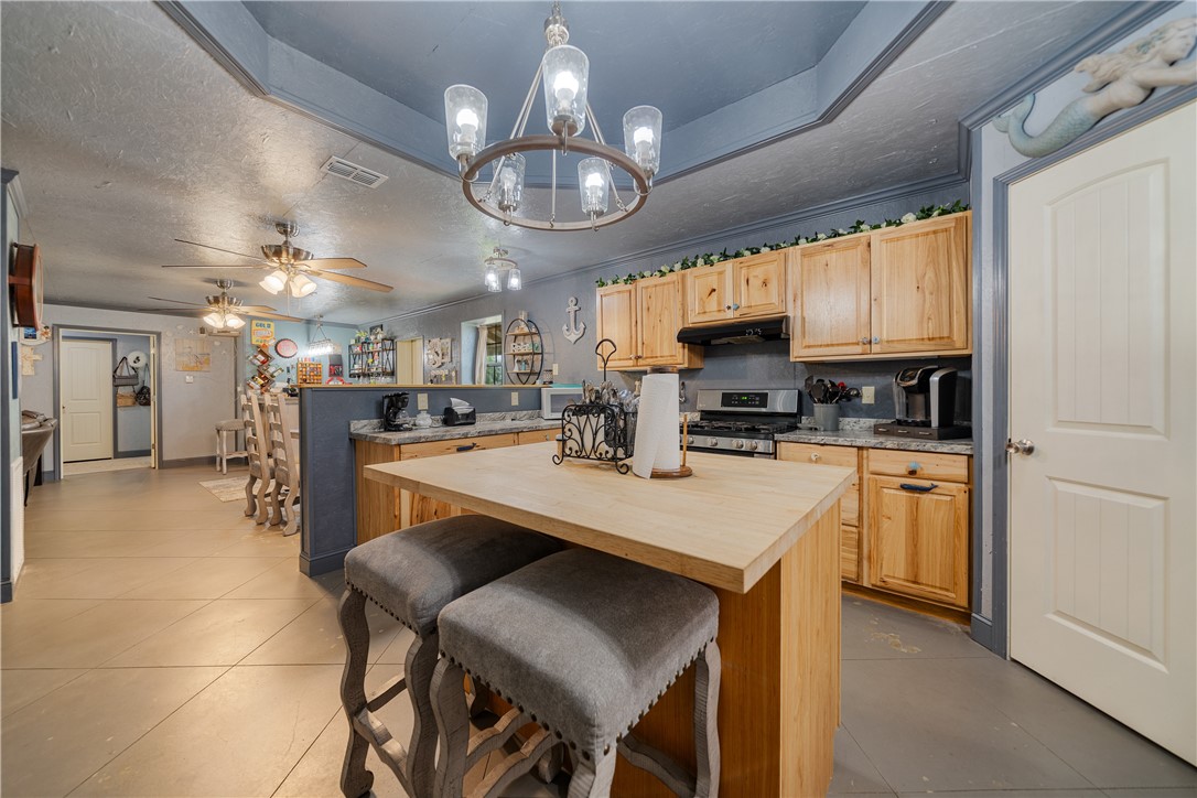 1356 Neubauer Point Road Riviera, TX 78379 - Photo 27 of 40 a kitchen with stainless steel appliances granite countertop a sink a stove a refrigerator cabinets and chairs