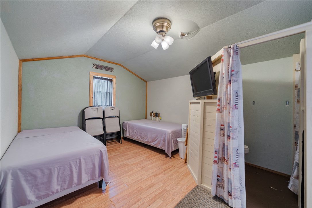 1356 Neubauer Point Road Riviera, TX 78379 - Photo 38 of 40 a spacious bedroom with a bed and a chandelier