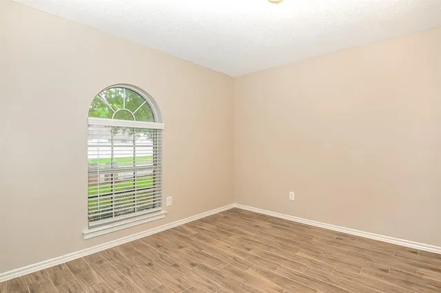 an empty room with wooden floor and a window
