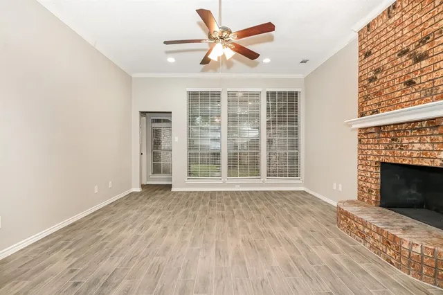 wooden floor fireplace and windows in an empty room