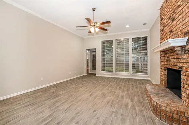 a view of an empty room with a fireplace and a window