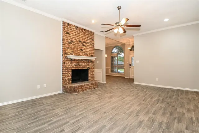 a view of an empty room with a fireplace and a window