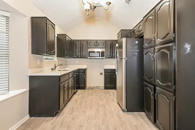 a kitchen with stainless steel appliances a sink stove and refrigerator