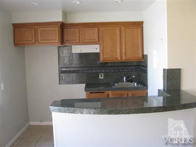 1925 Ginger Street, Unit 225 Oxnard, CA 93036 - Photo 2 of 5 a kitchen with granite countertop a sink a stove and granite counter tops