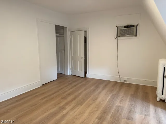 an empty room with wooden floor and a window