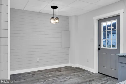 a view of empty room with wooden floor and window