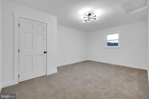 an empty room with fan and windows