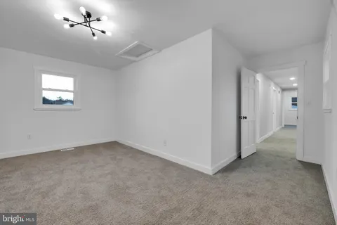an empty room with a ceiling fan and window