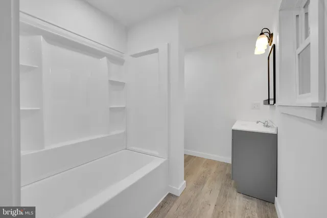 a bathroom with a tub sink and mirror