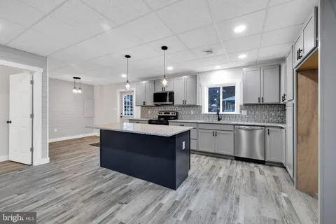 a large kitchen with stainless steel appliances granite countertop a stove and a refrigerator