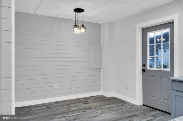 a view of empty room with wooden floor and window