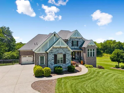 a front view of a house with a yard and trees