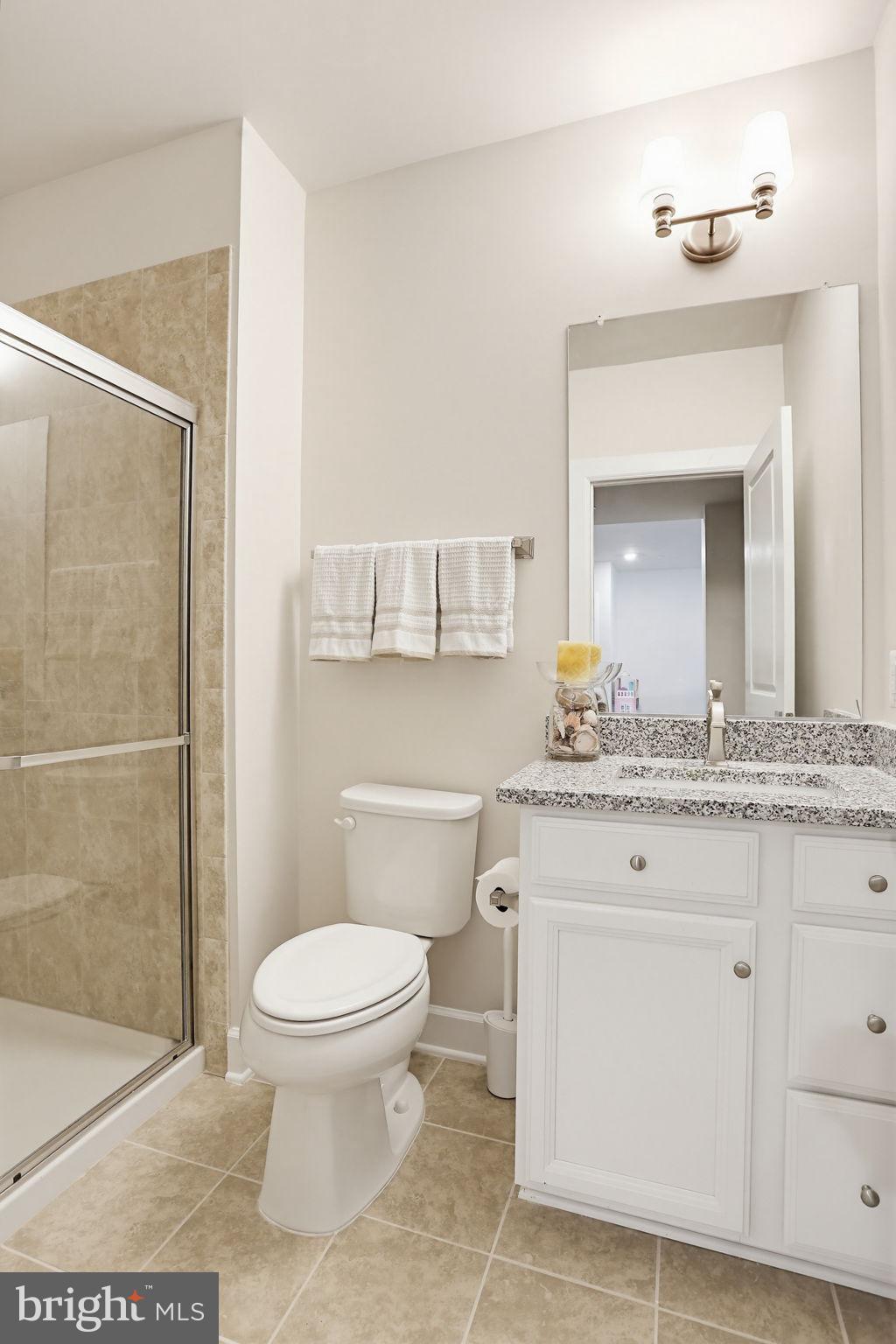 3816 Fulham Road Frederick, MD 21704 - Photo 39 of 77 a bathroom with a granite countertop toilet sink and mirror