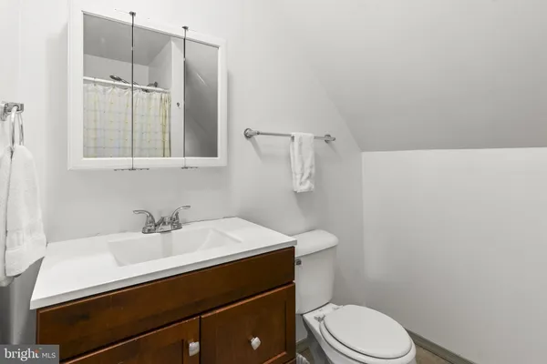 a bathroom with a sink vanity mirror and toilet