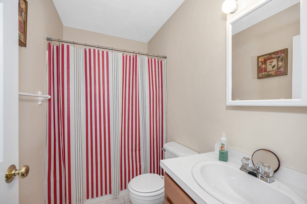 39 Broadway, Unit 305 Malden, MA 02148 - Photo 23 of 36 a bathroom with a granite countertop sink and a toilet