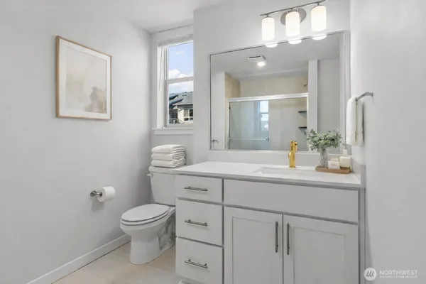 a spacious bathroom with a toilet sink and mirror