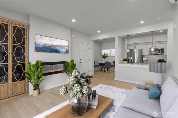 a living room with furniture potted plant and kitchen view
