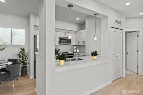 a kitchen with a sink a counter appliances and cabinets