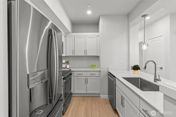 a kitchen with stainless steel appliances a sink stove and refrigerator