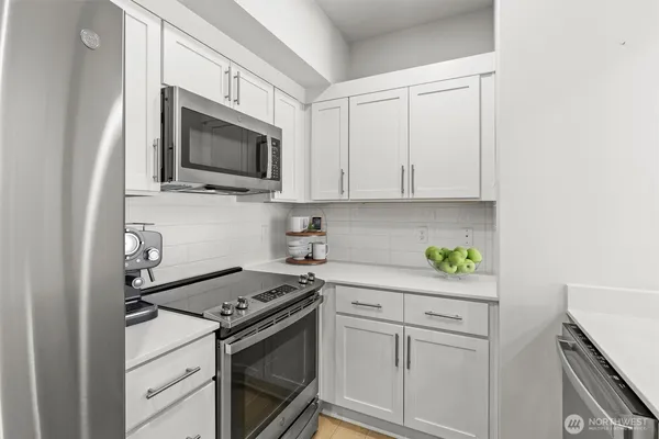 a kitchen with white cabinets and appliances