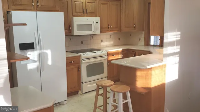 a kitchen with stainless steel appliances granite countertop a refrigerator sink and white cabinets