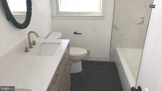 a bathroom with a sink toilet and a mirror