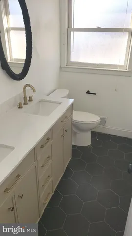 a bathroom with a toilet a sink and mirror