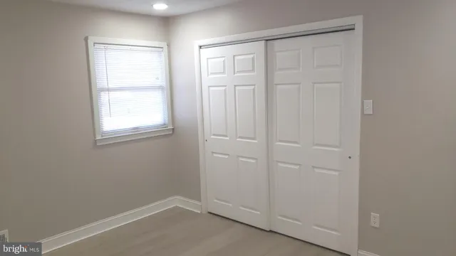 an empty room with windows and closet