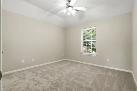 an empty room with a window and a fan