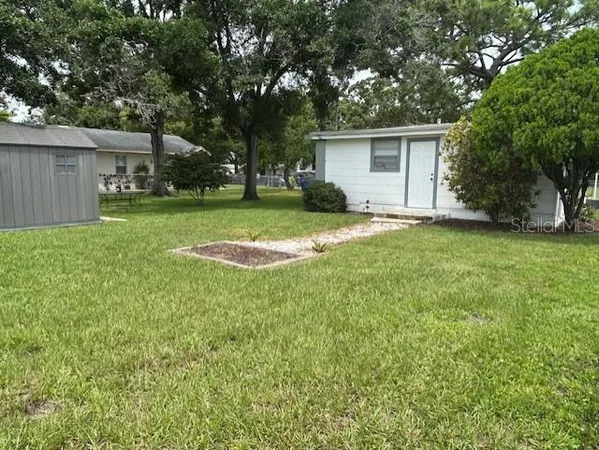 an aerial view of residential houses with outdoor space and trees