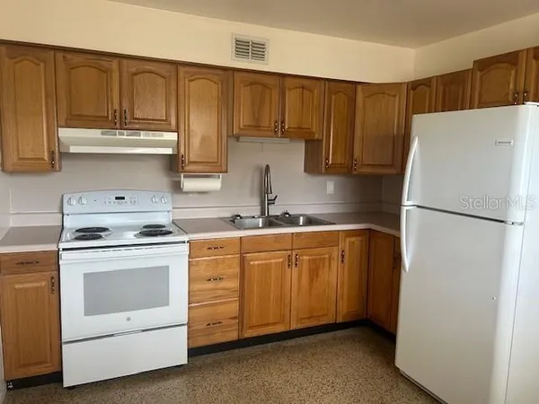 a kitchen with stainless steel appliances granite countertop a refrigerator sink and cabinets