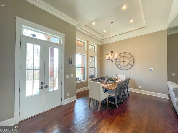 a view of a dining room with furniture a chandelier and wooden floor