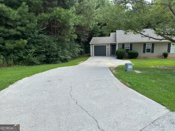 a front view of a house with a yard and trees