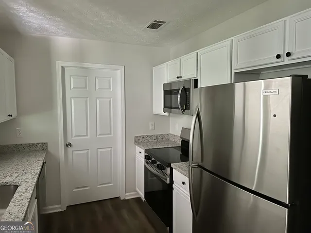 a kitchen with stainless steel appliances granite countertop a refrigerator and a stove