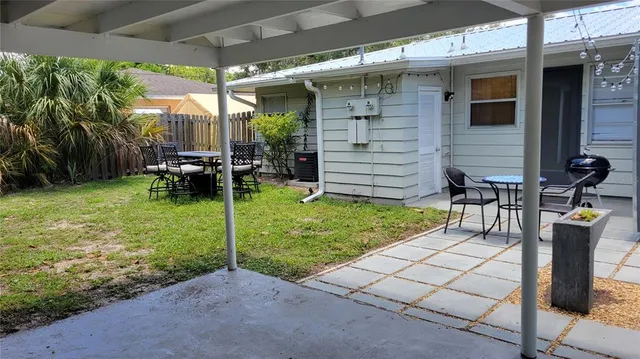 a view of a chair and table in backyard of the house